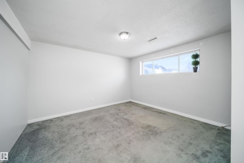 Room featuring light gray walls, gray carpet flooring, a single window, and a flush-mount ceiling light fixture - 5303 21 Avenue, Edmonton, AB - Indoor Photo Showing Other Room