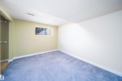 Spacious room featuring light gray carpet flooring, a window with white trim, and a white ceiling with an air vent - 5303 21 Avenue, Edmonton, AB - Indoor Photo Showing Other Room
