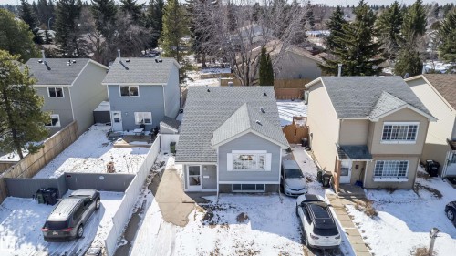 Gray siding residence featuring a gabled roof, white-trimmed windows, and a partially fenced rear yard - 5303 21 Avenue, Edmonton, AB - Outdoor