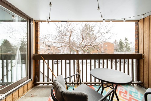 Private balcony featuring wood-look paneling and a brick accent wall - 220 14819 51 Avenue, Edmonton, AB -  Photo Showing Other Room