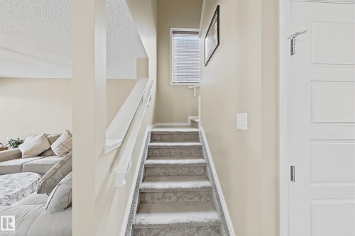 Carpeted staircase with white handrail and neutral wall paint - 3609 Weidle Bend Bend, Edmonton, AB - Indoor Photo Showing Other Room