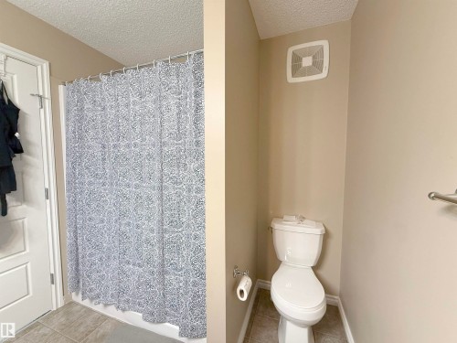 Bathroom featuring a shower with white surround, a white toilet, and neutral wall paint - 3609 Weidle Bend Bend, Edmonton, AB - Indoor Photo Showing Bathroom
