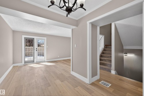Open-concept room featuring light wood-finish flooring, neutral wall paint, and white trim - 11 Greenfield Estates, St. Albert, AB - Indoor Photo Showing Other Room