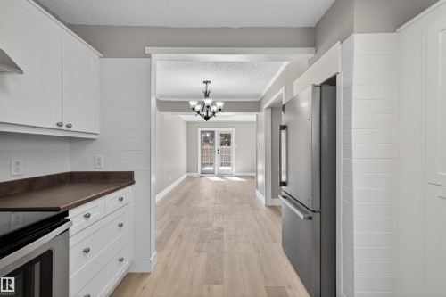 Kitchen featuring white shaker-style cabinetry, dark wood-finish countertops, and a stainless steel appliance suite including a range and refrigerator - 11 Greenfield Estates, St. Albert, AB - Indoor Photo Showing Kitchen