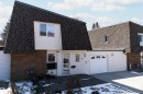 Front facade featuring a gambrel roof, white siding, and brick accents - 11 Greenfield Estates, St. Albert, AB  - Outdoor With Exterior 
