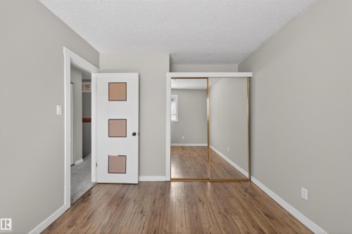 Interior space featuring wood-finish flooring, light gray wall paint, and white baseboards - 11 Greenfield Estates, St. Albert, AB - Indoor Photo Showing Other Room