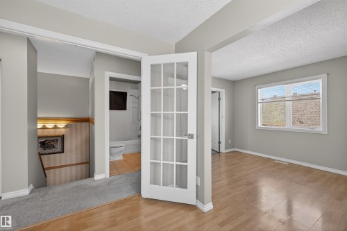 Hardwood-style flooring in a brightly lit room featuring a large window - 11 Greenfield Estates, St. Albert, AB - Indoor Photo Showing Other Room