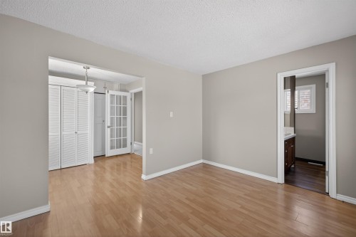 Light wood-finish flooring complements neutral wall tones - 11 Greenfield Estates, St. Albert, AB - Indoor Photo Showing Other Room