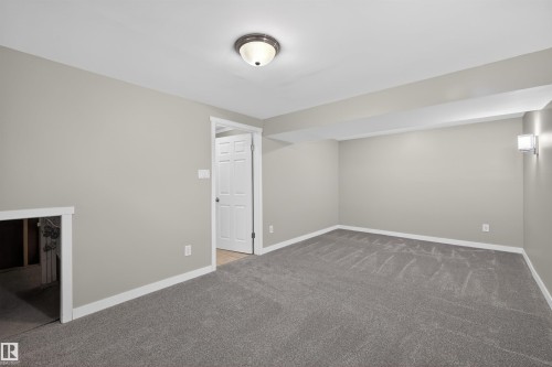 Spacious interior room featuring gray carpeting, light gray wall paint, and white baseboards - 11 Greenfield Estates, St. Albert, AB - Indoor Photo Showing Other Room