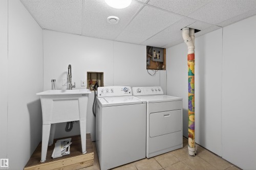 Dedicated laundry area featuring a utility sink with a high-arc faucet, tiled flooring, and a dropped ceiling - 11 Greenfield Estates, St. Albert, AB - Indoor Photo Showing Laundry Room