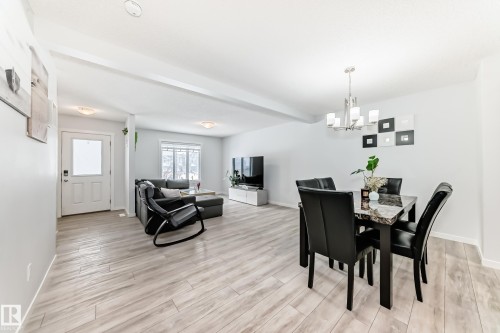 Open-concept living space featuring light wood-finish flooring, recessed lighting, and a contemporary chandelier - 2505 14 Avenue, Edmonton, AB - Indoor Photo Showing Other Room