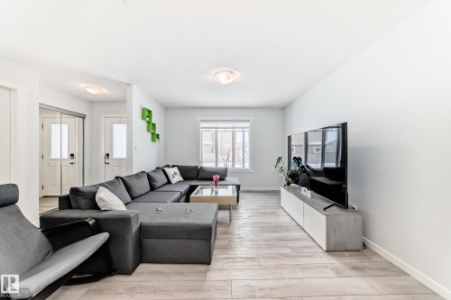 Open-concept living area featuring wood-finish flooring, recessed lighting, and bright white walls - 2505 14 Avenue, Edmonton, AB - Indoor Photo Showing Living Room