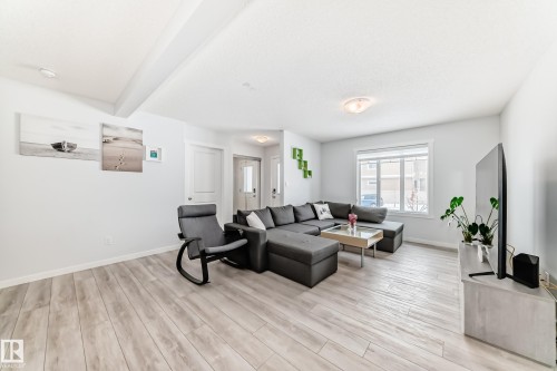 Spacious living area featuring light wood-finish flooring, recessed lighting, and a large window - 2505 14 Avenue, Edmonton, AB - Indoor Photo Showing Living Room
