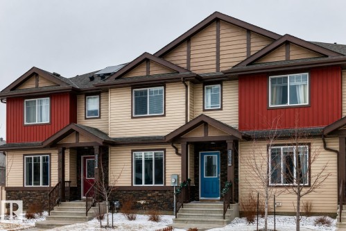Contemporary townhome exterior featuring multi-toned siding, dark trim accents, and a stone facade - 2505 14 Avenue, Edmonton, AB - Outdoor With Facade