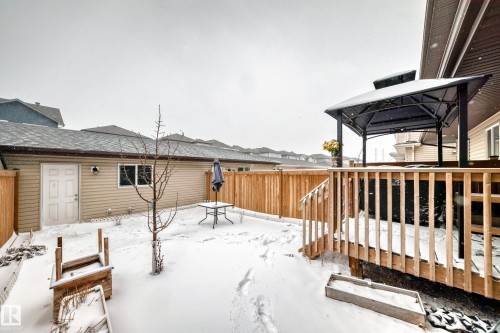 Expansive backyard featuring a wood deck with a gazebo, full wood privacy fencing, and a detached structure with siding and a window - 2505 14 Avenue, Edmonton, AB - Outdoor With Exterior