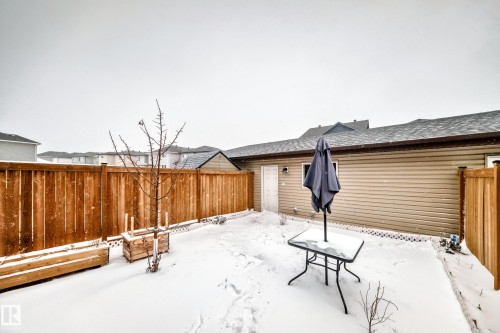 Private backyard featuring a full wood fence, a rear exterior wall with horizontal siding, and a back door - 2505 14 Avenue, Edmonton, AB - Outdoor