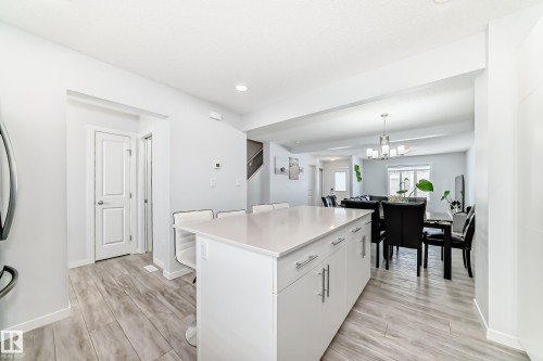 Kitchen island featuring white cabinetry, a light-toned countertop, and bar seating - 2505 14 Avenue, Edmonton, AB - Indoor