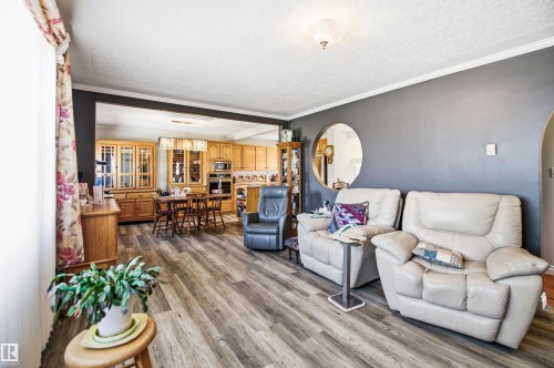Wood-finish flooring throughout, with a recessed archway opening to an additional room - 3920 35A Avenue, Red Deer, AB - Indoor Photo Showing Living Room