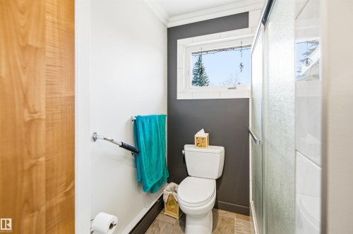 Bathroom with a white toilet, frosted glass shower enclosure, and a window with white trim - 3920 35A Avenue, Red Deer, AB - Indoor Photo Showing Bathroom
