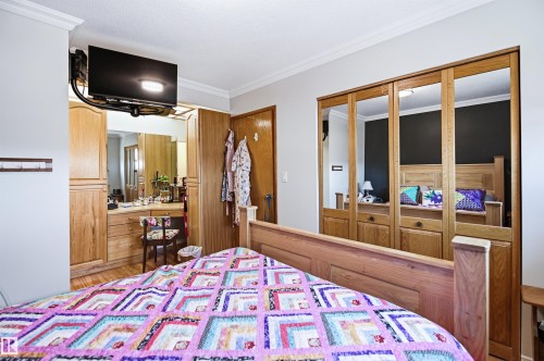 Hardwood flooring and crown molding accent the space - 3920 35A Avenue, Red Deer, AB - Indoor Photo Showing Bedroom