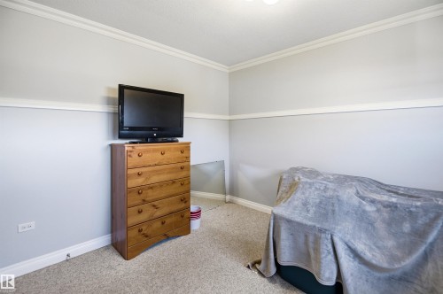Carpeted room with light grey walls, white baseboards, and crown molding - 3920 35A Avenue, Red Deer, AB - Indoor