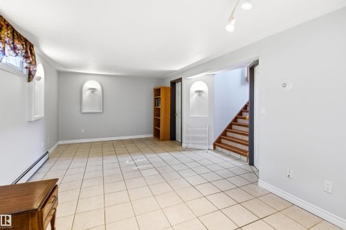 Spacious room featuring neutral tile flooring, light gray wall paint, and white trim - 3920 35A Avenue, Red Deer, AB - Indoor Photo Showing Other Room