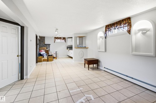Spacious room featuring tile flooring, built-in wall niches with sconce lighting, and a stone-faced accent wall - 3920 35A Avenue, Red Deer, AB - Indoor Photo Showing Other Room