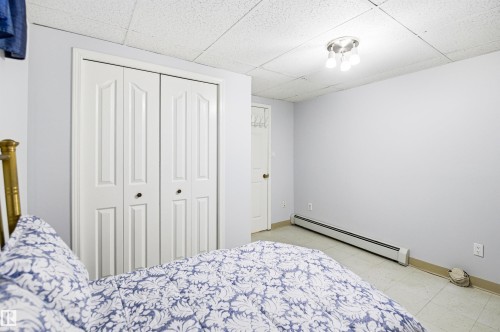 White bi-fold closet doors with black hardware, light blue wall paint, and white trim - 3920 35A Avenue, Red Deer, AB - Indoor Photo Showing Bedroom