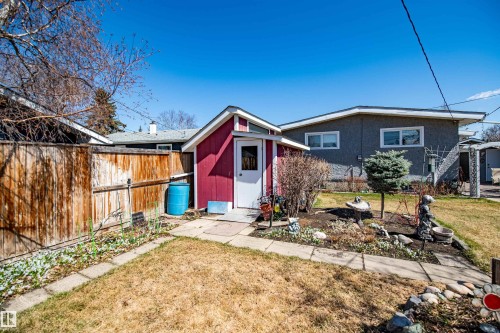 Red storage shed with a white door, set on a stone paver path - 3920 35A Avenue, Red Deer, AB - Outdoor