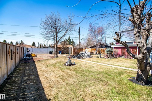 Expansive backyard featuring a natural grass lawn and mature trees - 3920 35A Avenue, Red Deer, AB - Outdoor