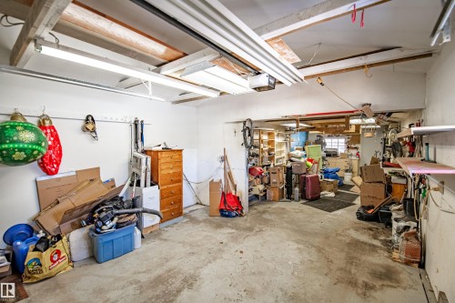 Garage space featuring exposed ceiling beams, concrete flooring, and fluorescent lighting fixtures - 3920 35A Avenue, Red Deer, AB - Indoor Photo Showing Garage