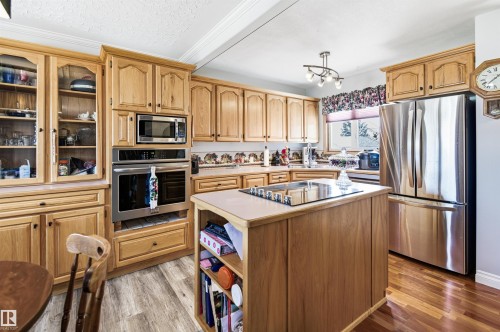 Kitchen featuring light wood cabinetry, stainless steel appliances, a built-in oven and microwave, and an island with a cooktop - 3920 35A Avenue, Red Deer, AB - Indoor Photo Showing Kitchen