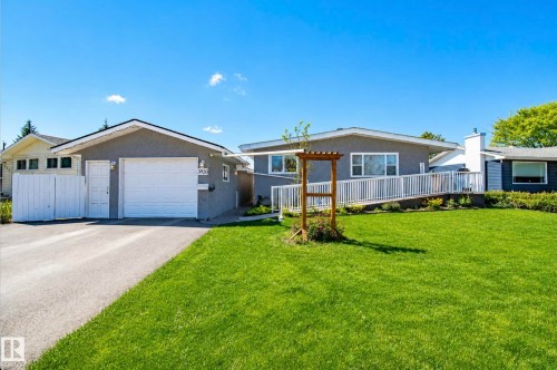 Grey stucco exterior with a prominent attached garage and a paved driveway - 3920 35A Avenue, Red Deer, AB - Outdoor With Deck Patio Veranda