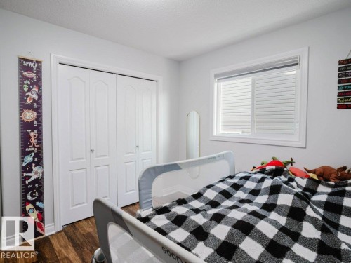 Kid's bedroom - White walls with wood-finish flooring - 5701 Rue Eaglemont, Beaumont, AB - Indoor Photo Showing Bedroom