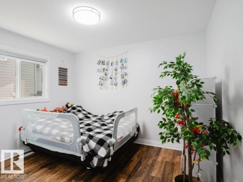 Room featuring wood-finish flooring, a white ceiling, and a flush-mount ceiling light - 5701 Rue Eaglemont, Beaumont, AB - Indoor Photo Showing Bedroom