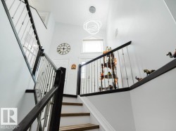 Staircase featuring dark wood handrails and metal balusters - 