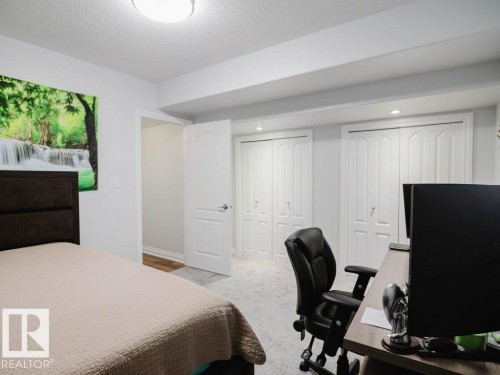 Carpeted room featuring a white interior door, two bi-fold closet doors with paneling, and recessed lighting - 5701 Rue Eaglemont, Beaumont, AB - Indoor Photo Showing Bedroom