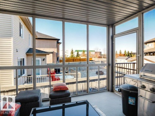 Enclosed sunroom featuring expansive window panels, a textured ceiling, and light-toned flooring - 5701 Rue Eaglemont, Beaumont, AB - Indoor