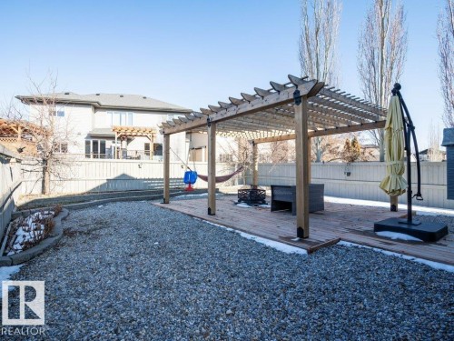 Expansive backyard featuring a large gravel area, a wood deck with a pergola, and a privacy fence - 5701 Rue Eaglemont, Beaumont, AB - Outdoor