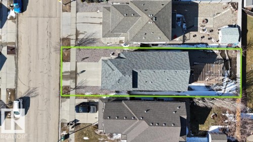 Asphalt shingle roofing, paved driveway, concrete sidewalk, front yard with landscaping beds, and backyard with deck and storage shed - 5701 Rue Eaglemont, Beaumont, AB - 