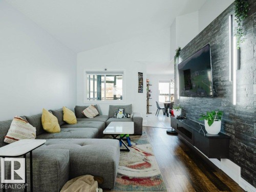 Living room featuring vaulted ceilings and wood-finish flooring - 5701 Rue Eaglemont, Beaumont, AB - Indoor Photo Showing Living Room
