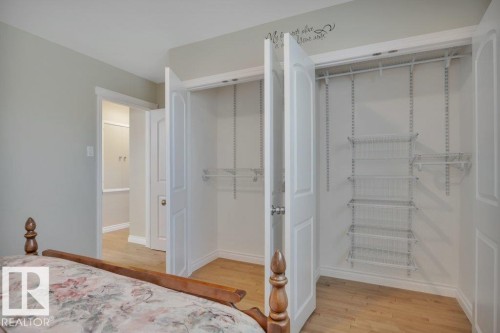 Twin closets with white panel doors, featuring adjustable wire shelving and hanging rods - 10633 St Gabriel School Road, Edmonton, AB - Indoor Photo Showing Bedroom