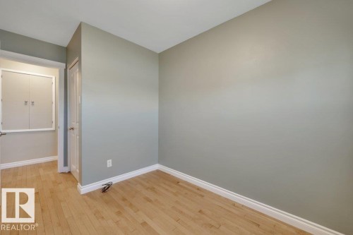 Neutral tone walls, light wood-finish flooring, white baseboards, and a white interior door - 10633 St Gabriel School Road, Edmonton, AB - Indoor Photo Showing Other Room