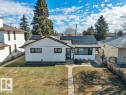 Single-story residence featuring a white siding exterior, dark trim windows, and a dark shingle roof equipped with solar panels - 10633 St Gabriel School Road, Edmonton, AB  - Outdoor 