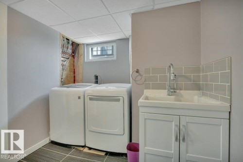 Dedicated utility area featuring a drop ceiling, window, and wood-finish flooring - 10633 St Gabriel School Road, Edmonton, AB - Indoor Photo Showing Laundry Room