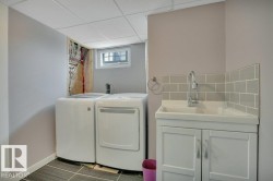 Dedicated utility area featuring a drop ceiling, window, and wood-finish flooring - 