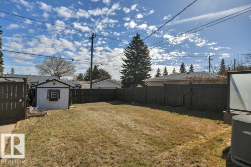 Expansive fenced backyard featuring a storage shed with decorative window shutters and a side gate - 10633 St Gabriel School Road, Edmonton, AB - Outdoor