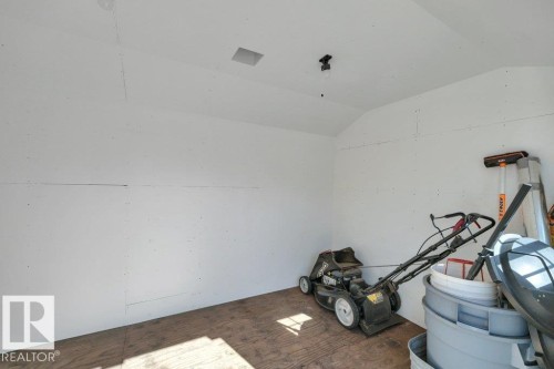 Interior storage space featuring a vaulted ceiling and wood-finish flooring - 10633 St Gabriel School Road, Edmonton, AB - Indoor