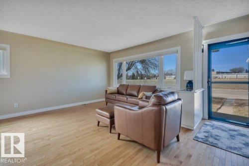 Living area featuring light wood-finish flooring, neutral wall paint, and white trim - 10633 St Gabriel School Road, Edmonton, AB - Indoor
