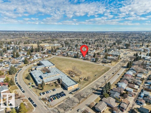 Residential area featuring individual homes, paved streets, and a large institutional building with a sports field - 10633 St Gabriel School Road, Edmonton, AB - Outdoor With View